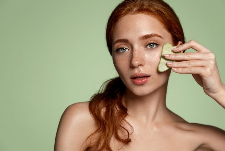 Redhead,Beautiful,Woman,Using,Skin,Care,Acupuncture,Gua,Sha,Jade